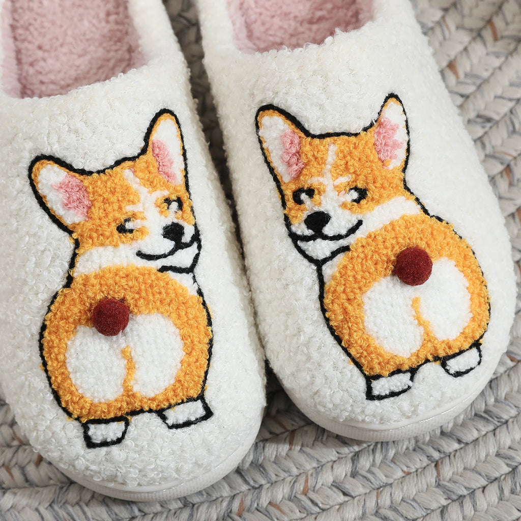 Pair of white slippers with corgi dog illustrations on a textured surface.