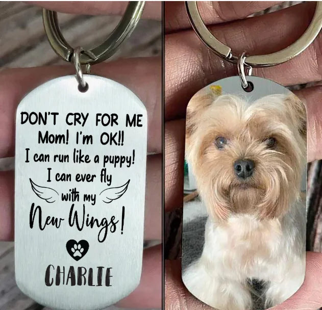 Dog tag keychain with text 'Don't cry for me Mom! I'm OK!! I can run like a puppy! I can ever fly with my New Wings! CHARLIE' and a dog photo.