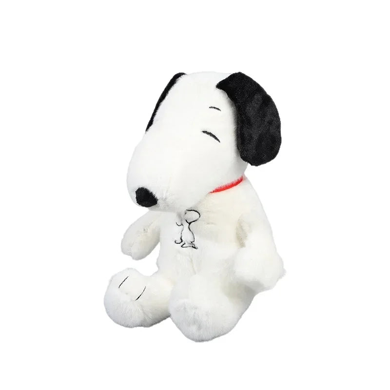 Plush toy resembling a black and white dog with a red collar on a white background